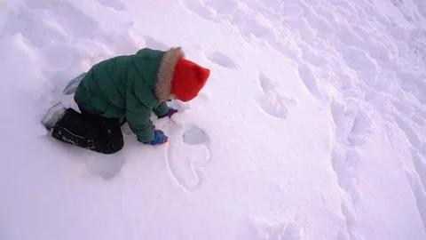 Cute little boy doing heart shape into the snow Stock Footage 146413199