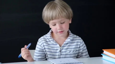 Cute little boy drawing at the table. Child from elementary school. Education Stock Footage 111759543