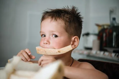 Cute little boy eating a slice of fresh melon Stock Photos