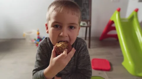 Cute little boy eats muffin at the home, close-up. Stock Footage 169382259