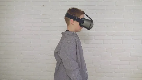 Cute little boy gesturing happily using VR virtual reality 360 degrees glasses. Stock Footage 84229987