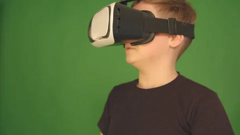 Cute little boy gesturing happily using VR virtual reality 360 degrees glasses Stock Footage 84638273