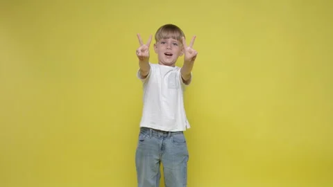 A cute little boy gesturing victory sign with hands Stock Footage 282106718