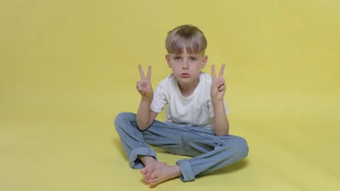 A cute little boy gesturing victory sign with hands Stock Footage 282108085