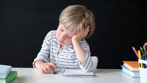 Cute little boy getting bored while studying. Child from elementary school at Stock Footage 111759374