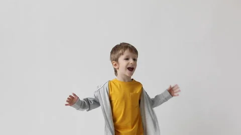 Cute little boy having fun close-up joyfully jumping waving his arms, celebra Stock Footage 168907226