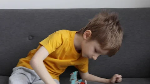 Cute little boy having fun, playing with a toy airplane in the living room Stock Footage 168907393