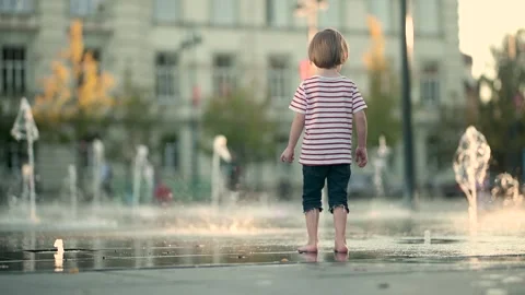 Cute little boy having fun with water in city fountain. 스톡 동영상 279429608