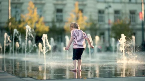 Cute little boy having fun with water in city fountain. 库存影片 280730874
