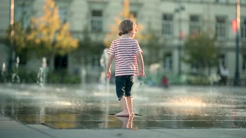 Cute little boy having fun with water in city fountain. 스톡 동영상 283098394