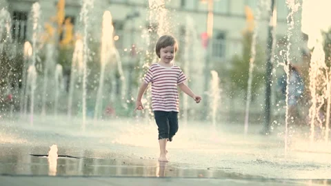 Cute little boy having fun with water in city fountain. 스톡 동영상 315260844