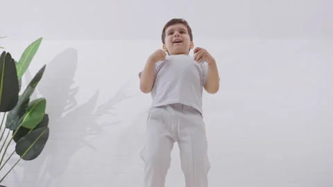Cute little boy jumping up and down on the bed in the morning Stock Footage 244355048