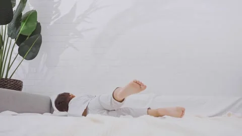 Cute little boy jumping and falling on the bed. Stock Footage 245877242