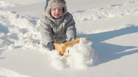 Cute little boy kid playing with toy truck and snow in winter Stock Footage 101500669