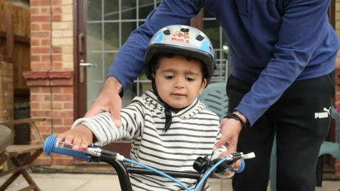 A cute little boy learning to ride a bike real lifestyle footage Vídeo Stock 131849124