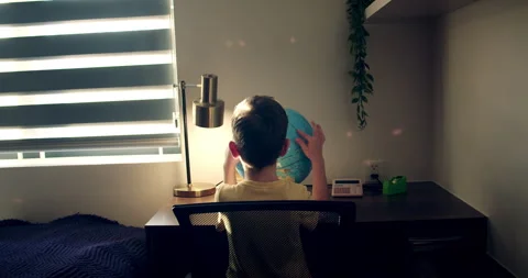 Cute little boy looking at globe through a magnifying glass, Kid in morning Stock Footage 265540944
