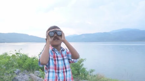 Cute little boy looking through binoculars Stock Footage 91878212