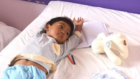 Cute little boy lying on the bed in room Stock Footage 73726767