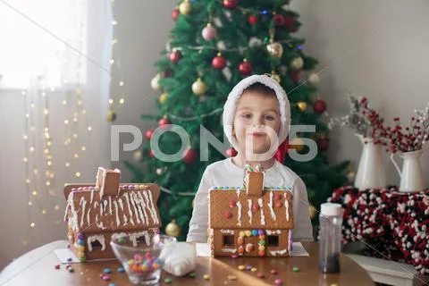 Cute little boy, making gingerbread cookies house for Christmas Stock Photos