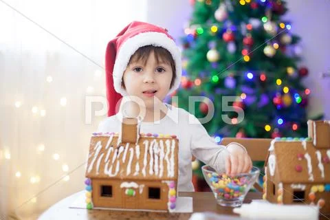 Cute little boy, making gingerbread cookies house for Christmas Stock Photos