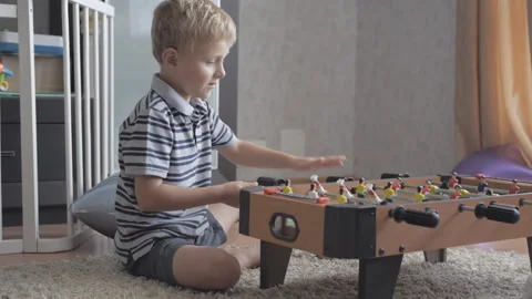 Cute little boy playing table football at home alone Stock Footage 158632580