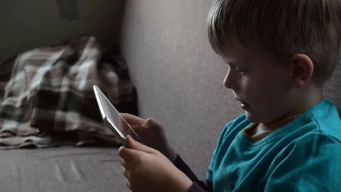 Cute little boy playing with tablet on sofa Stock Footage 73070797