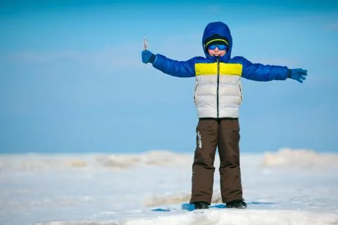 Cute little boy playing on winter beach Foto stock