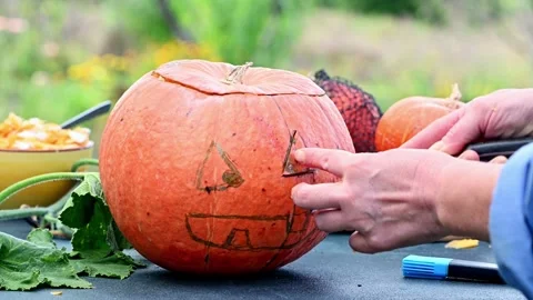 Cute little boy preparing Jack O' Lantern pumpkin for Halloween at home Getti Stock Footage 272458848