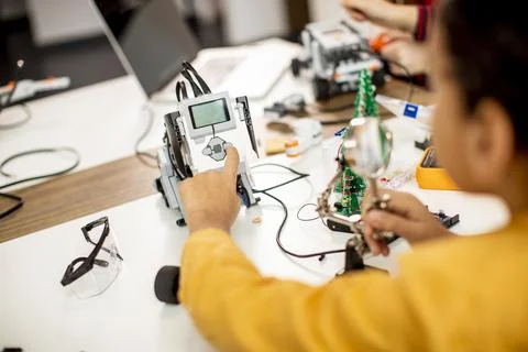 Cute little boy programming electric toys and robots at robotics classroom 库存照片