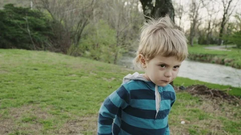 Cute Little Boy Sits Close To Water, Enjoys Looking At Scenery Stock-Footage 86802174