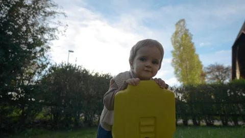 Cute little boy sits on small tractor looking in camera Stock Footage 228918480