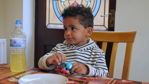 A cute little boy sitting at a dinner table real lifestyle footage Vídeo Stock 131849481