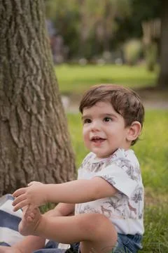 Cute little boy smiling while enjoying the day in a park. Stock Photos