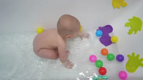 Cute little boy taking a bath with toys in a white bathroom. Stock Footage 170447647