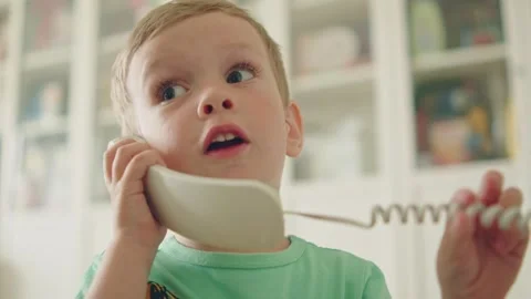 Cute little boy talking on a classic landline telephone at home. Stock Footage 335504772