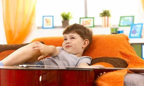 Cute little boy thinking on couch Cute little boy thinking on couch, pulli... Foto stock