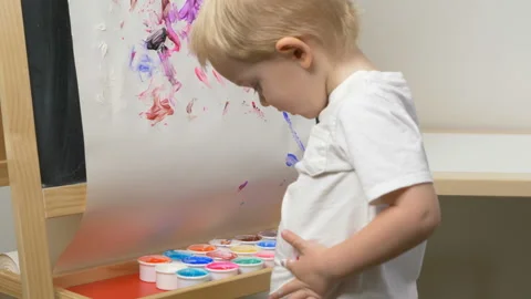 Cute little boy (toddler, two years old) is painting on tee Video stock 102377182