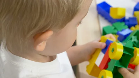 Cute little boy (toddler, two years old) is playing with Building bricks Stockbeeldmateriaal 102476326