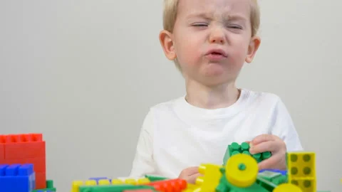 Cute little boy (toddler, two years old) is playing with Building bricks Видео 102477796