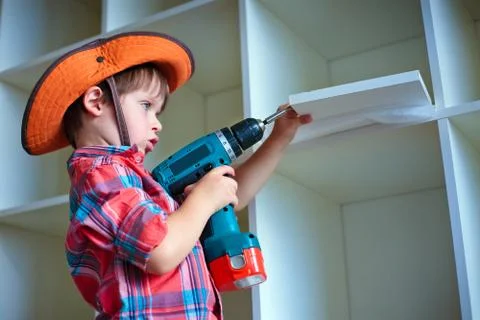 Cute little boy using an electric screwdriver Stock-Fotos
