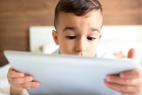 Cute little boy using his tablet Stock Photos