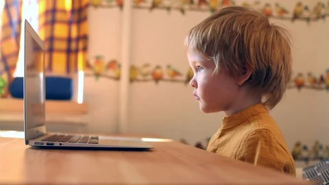 Cute little boy using modern laptop for video call, looking cartoons, educating Stock Footage 129015566