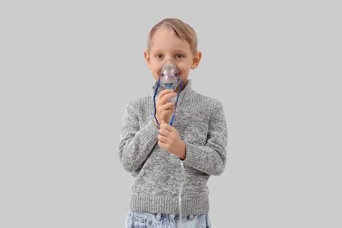 Cute little boy using nebulizer on light background Stock Photos