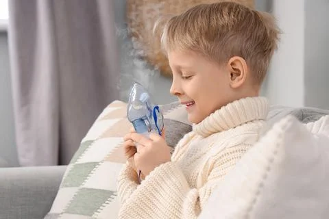 Cute little boy using nebulizer at home Stock Photos