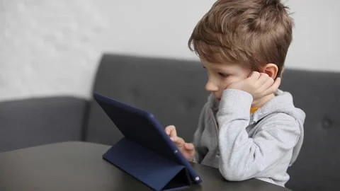 Cute little boy using pad. Child plays digital tablet at home. Free time, tec Stock Footage 168907109