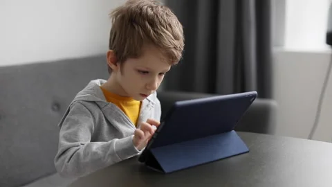 Cute little boy using pad. Child plays digital tablet at home. Free time, tec Stock Footage 169011597