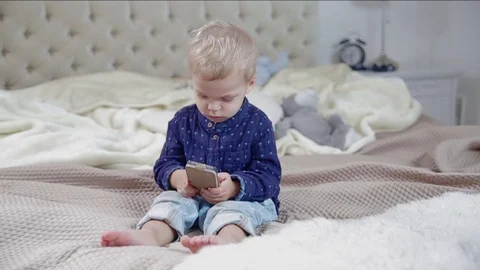 Cute little boy is using a smart phone. FULL HD. dolly shot. Stock Footage 73966532
