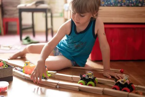 Cute little candid five year old kid boy playing at home with children's toys Stock Photos