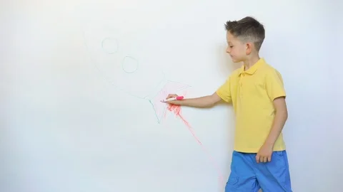Cute little child drawing rocket on white wall Stock Footage 114738237