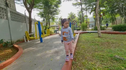Cute little child learning to walk on a narrow path Stock Footage 159440341